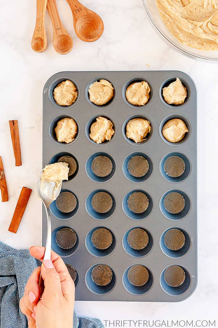 cinnamon sugar muffin batter being spooned into a muffin tin
