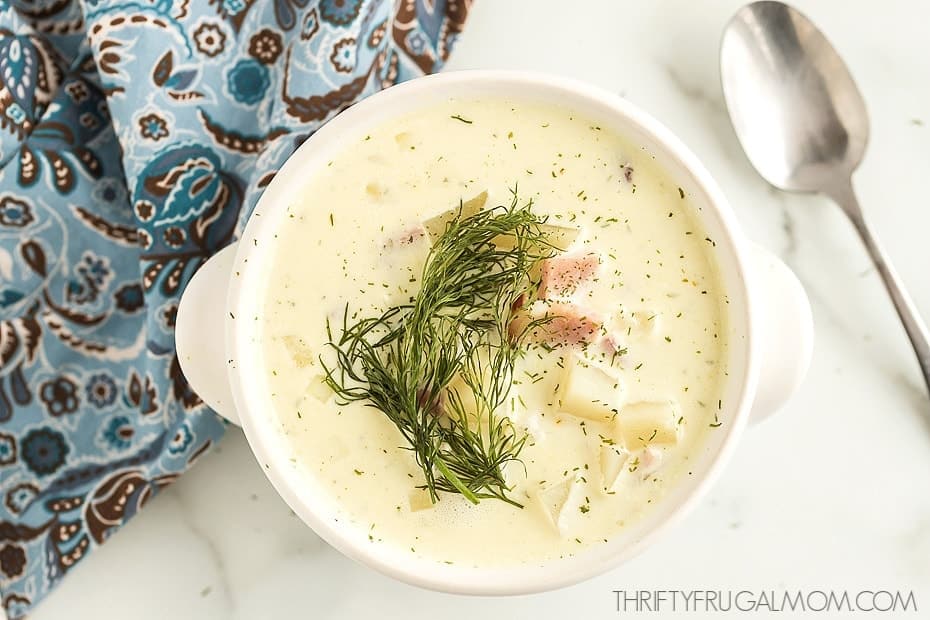 a white bowl full of cream cheese potato soup with ham and dill 