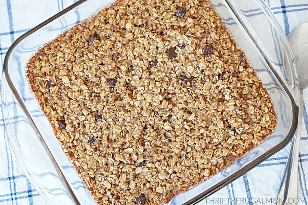 a glass baking dish of baked oatmeal with chocolate chips on a white and blue plaid background