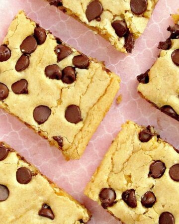 chocolate chip blonde brownie bars arranged on a pink plate