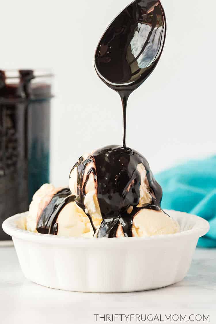 Homemade Hershey's chocolate syrup being spooned over vanilla ice cream