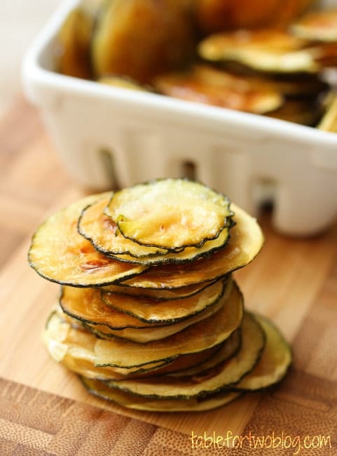 oven baked zucchini chips stacked on wooden table