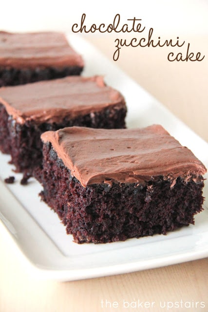 pieces of chocolate zucchini cake with chocolate icing on a white plate