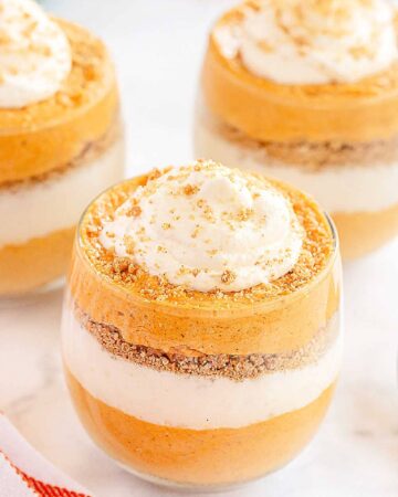 no bake pumpkin cheesecake trifles in glass cups on a white table