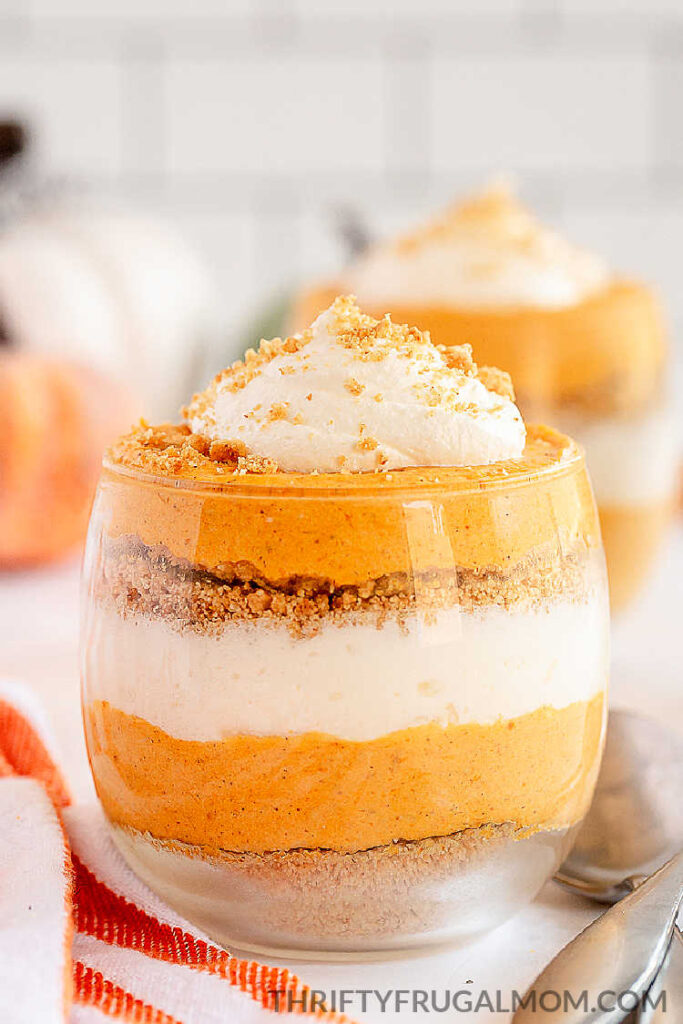 a closeup of layered no bake pumpkin cheesecake trifle in a glass 
