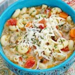 Creamy Italian sausage and pasta soup in a turquoise colored bowl