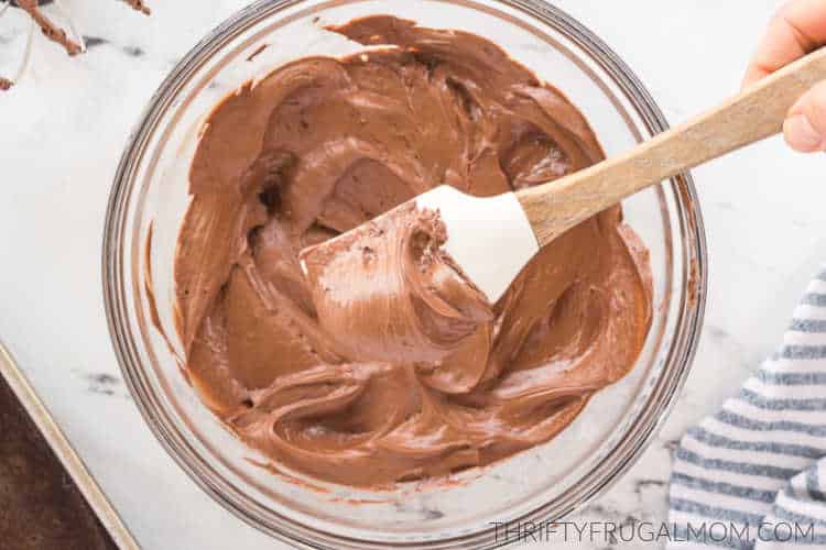 quick chocolate frosting in a glass mixing bowl with a spatula