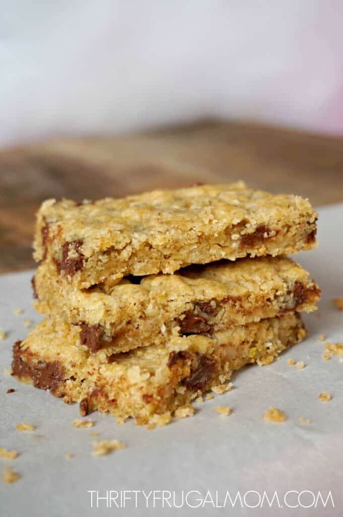 three chocolate chip oatmeal bars stacked on a sheet of parchment paper