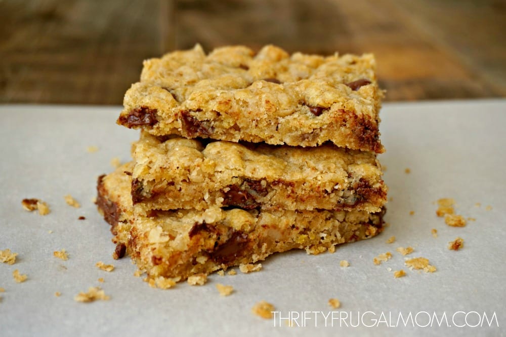 three chocolate chip oatmeal cookie bars stacked on each other on a sheet of parchment paper