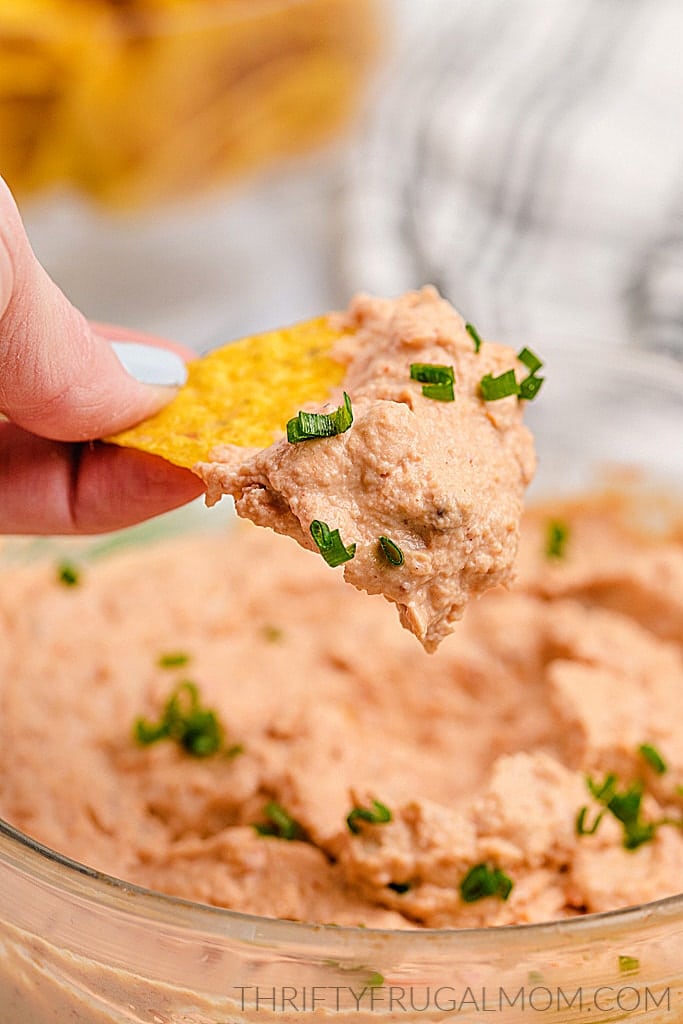 snack of healthy refried bean dip being scooped out on a tortilla chip