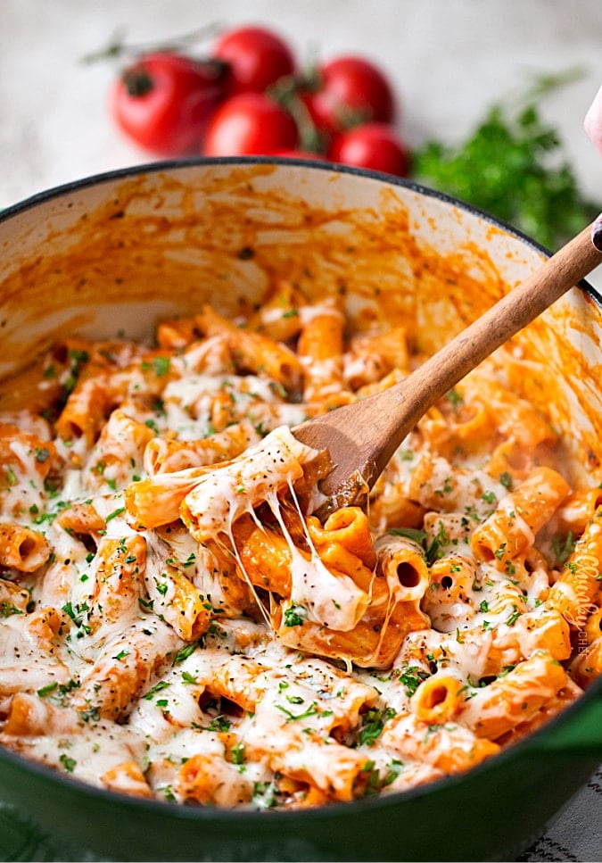 one pot chicken parmesan pasta in a kettle with a wooden spoon