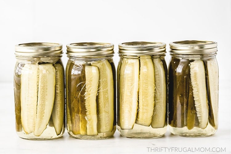 Canned Sweet Dill Pickle spears in canning jars on white table
