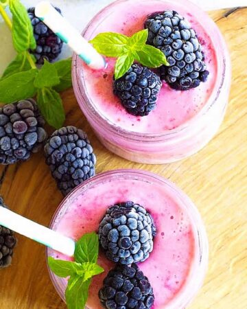 two cupfuls of frozen fruit smoothie with berries on top