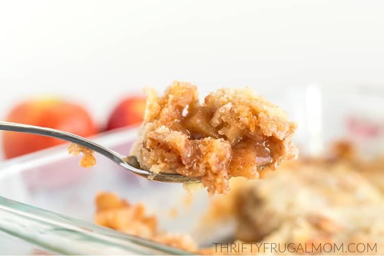 a Spoonful of Apple dump cake being scooped out of a baking dish