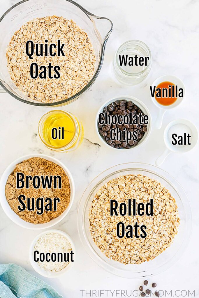 individual ingredients for chocolate granola in bowls on a white marble table