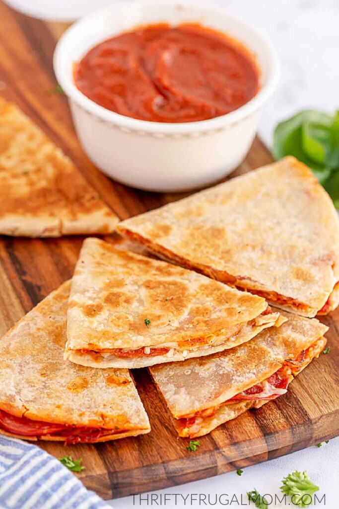 pepperoni pizza quesadillas on a wooden table with pizza sauce