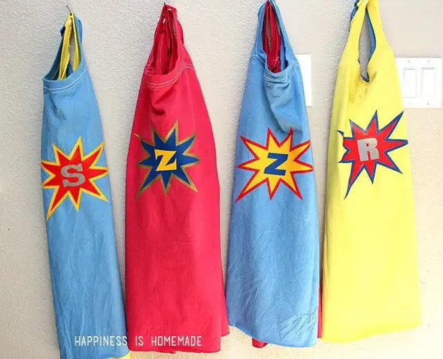 4 colorful DIY super hero capes hanging in a row