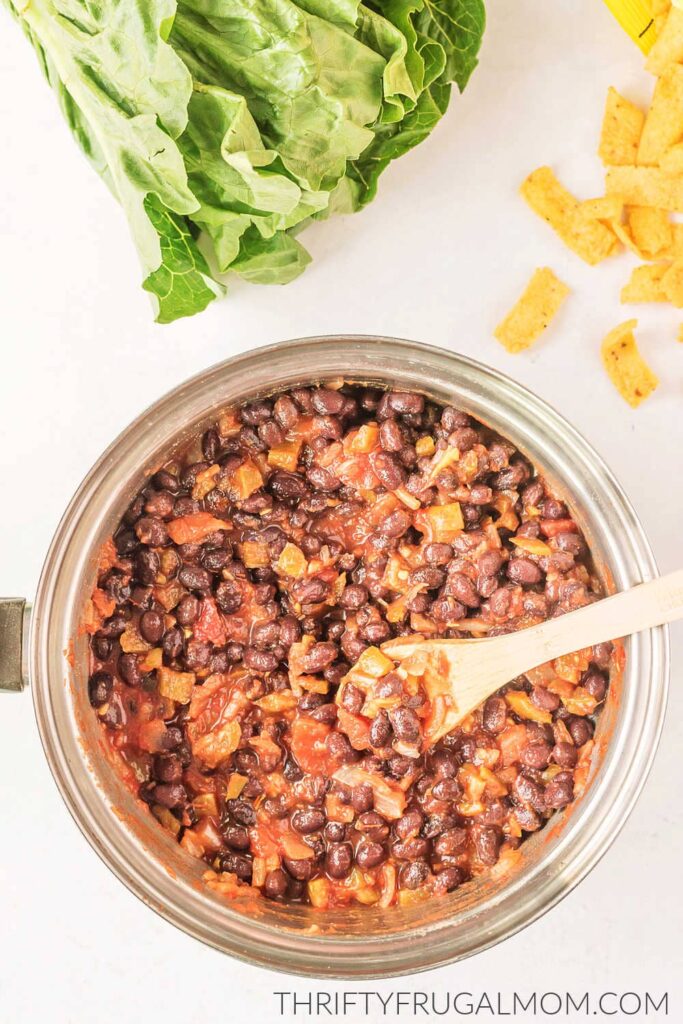 black beans and salsa in a pan with a wooden spoon in it