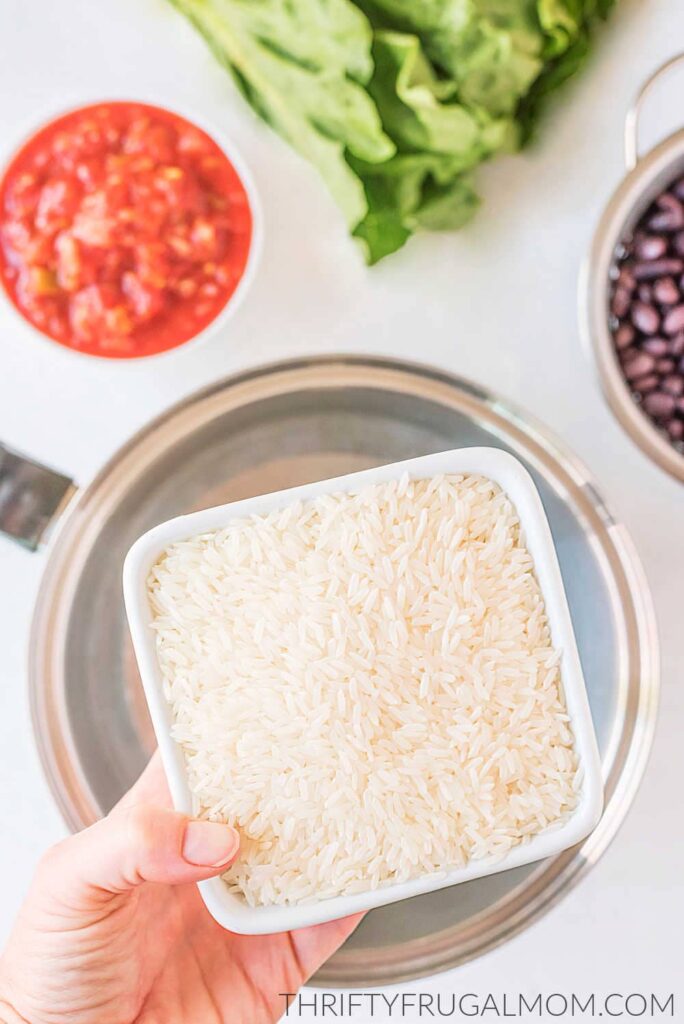 dry rice being held above a kettle of water