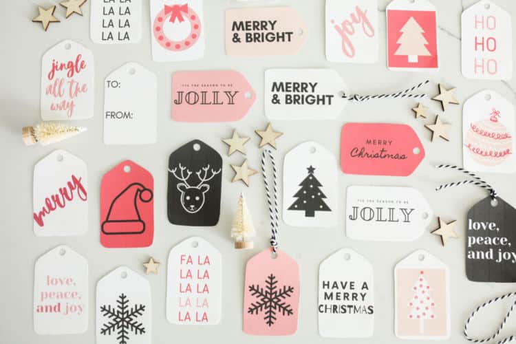 a bunch of cute, simple black and white and pink Christmas gift tags on a white table