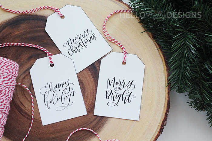 3 simple free black and white Christmas gift tags on a wooden board