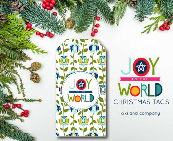a colorful free printable Joy to the World gift tag with greenery arranged around it