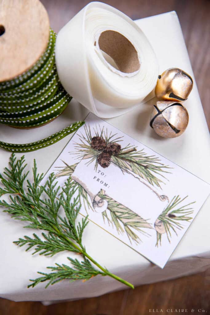a gift with gift wrapping supplies and a printable pine cone holiday gift tag 