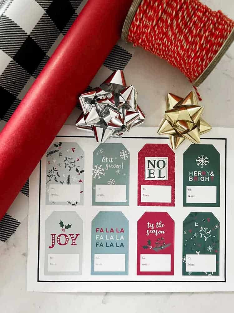 pretty colorful printable gift tags for Christmas on a table with gift wrap