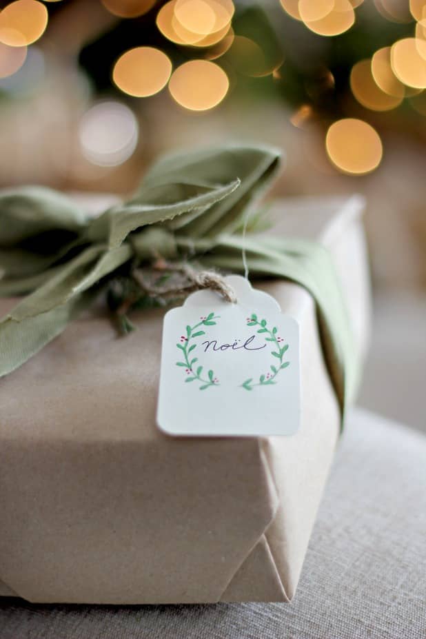 a brown paper package tied up with a simple Noel watercolor free printable gift tag