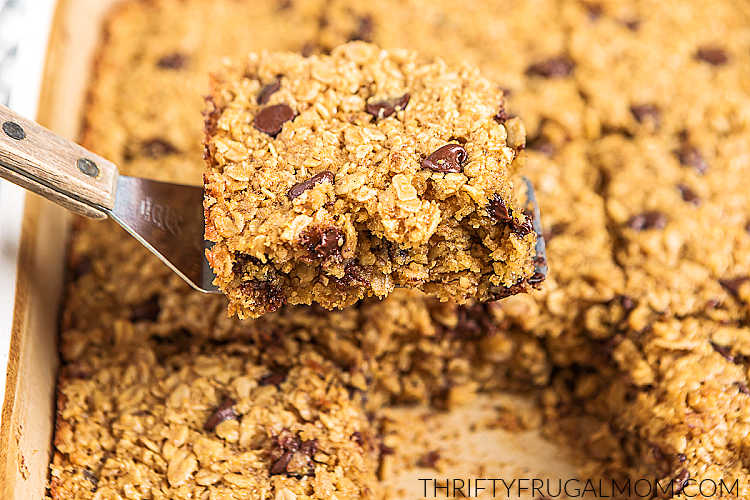 scooping a square of chocolate chip baked oatmeal out of a baking dish