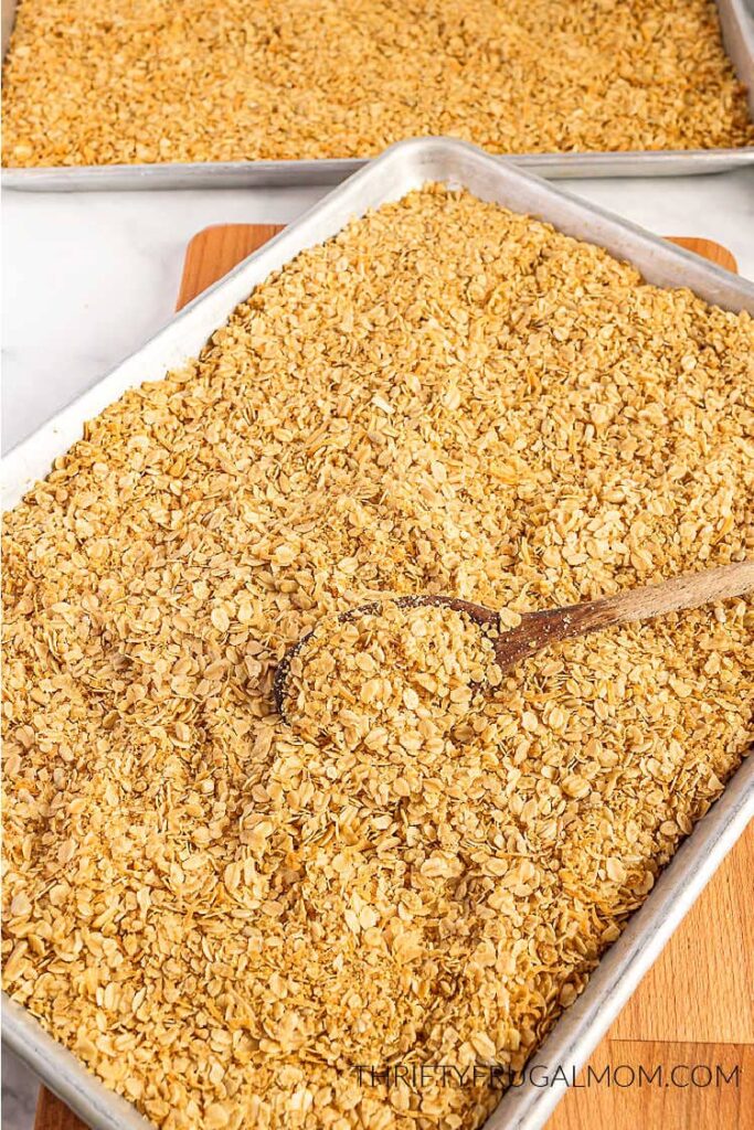 homemade granola in a baking pan with wooden spoon