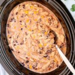 slow cooker Mexican chicken with a large silver spoon in the pot
