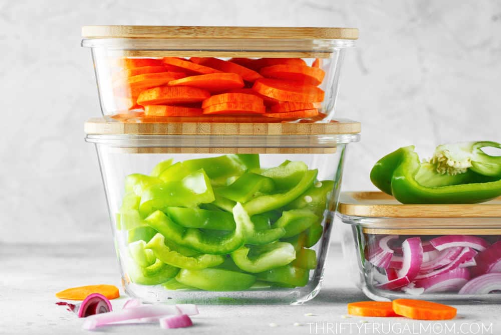 glass containers with wooden lids filled with fresh cut vegetables
