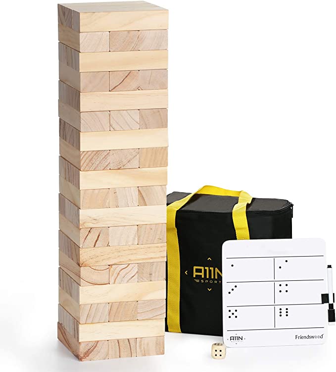 a large outdoor wooden Jenga game stacked with a carrying bag beside it
