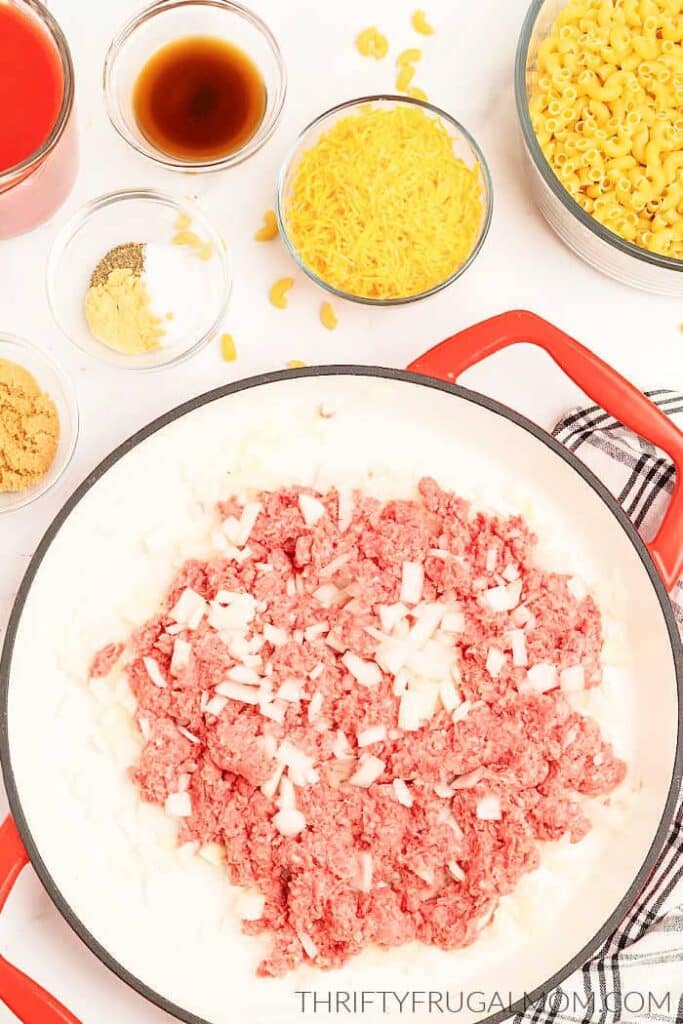 Ground beef and onion in a skillet ready to brown