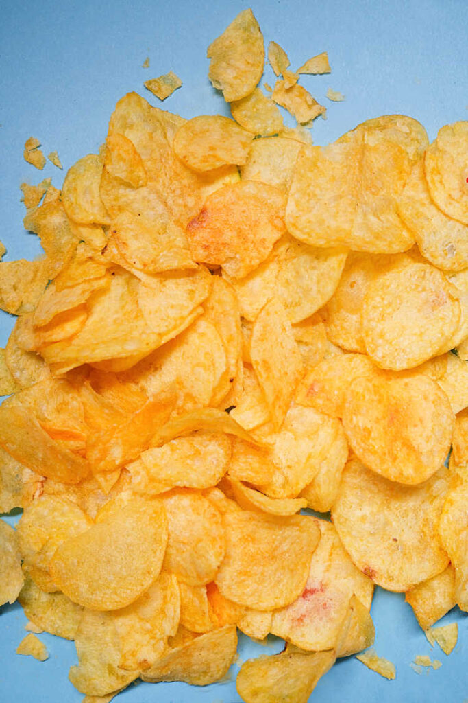a pile of potato chips on a blue surface