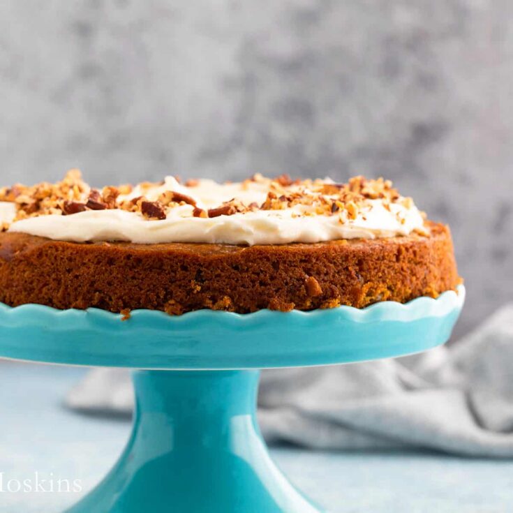 an egg free carrot cake on an aqua cake stand