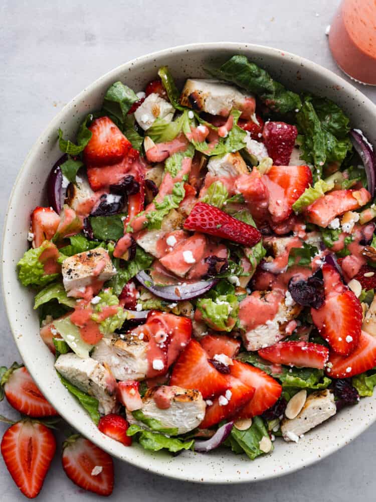 strawberry chicken salad next to chopped berries. 