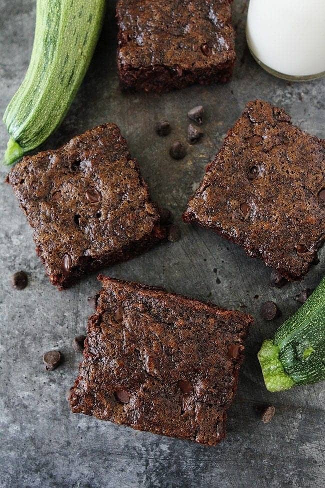 chocolate zucchini brownies on a countertop with fresh zucchini