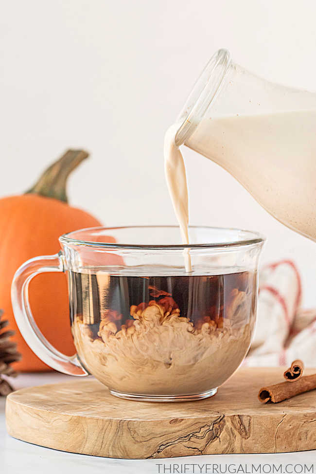 Pouring homemade pumpkin creamer into a coffee cup.